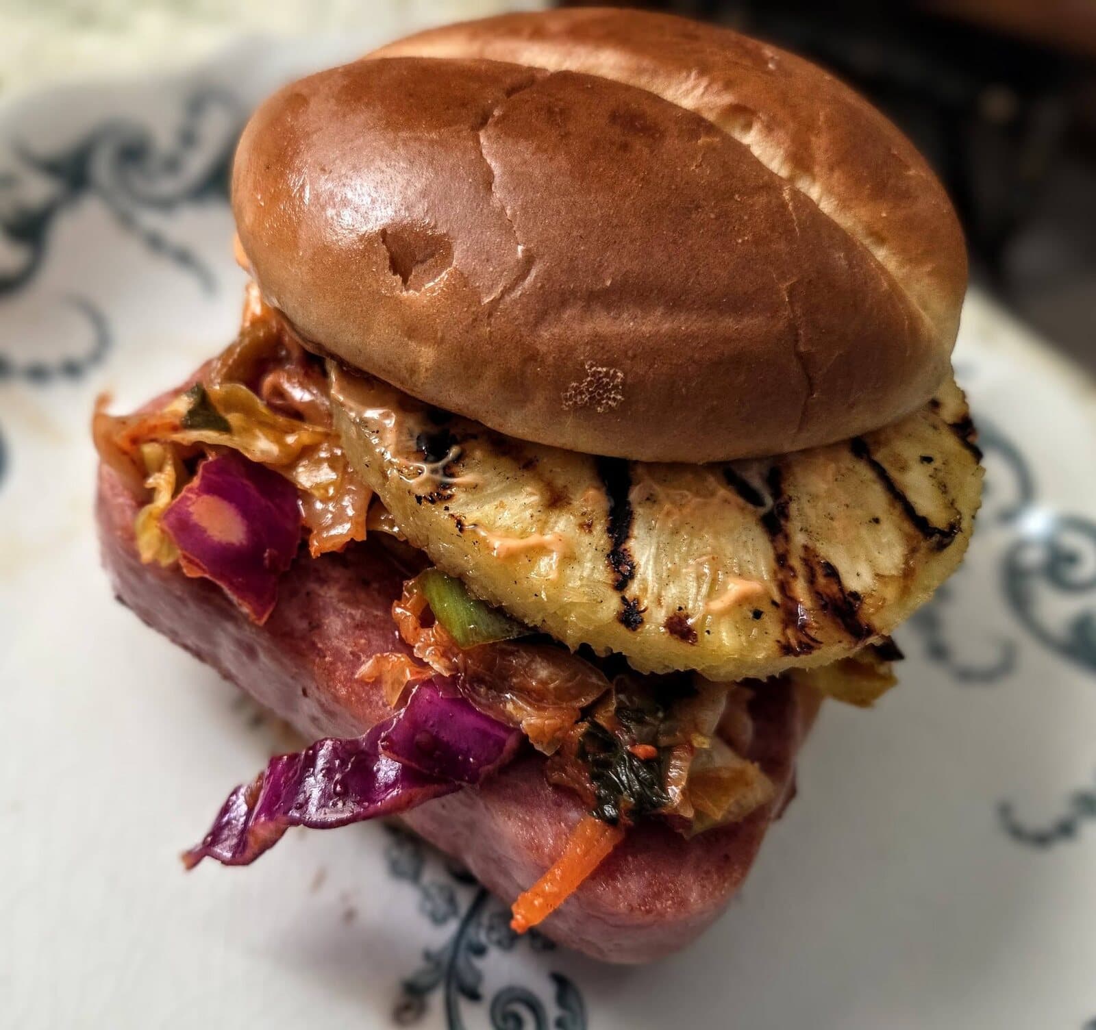 A TNLU sandwich — grilled pineapple, kimchi slaw and spam on a brioche bun